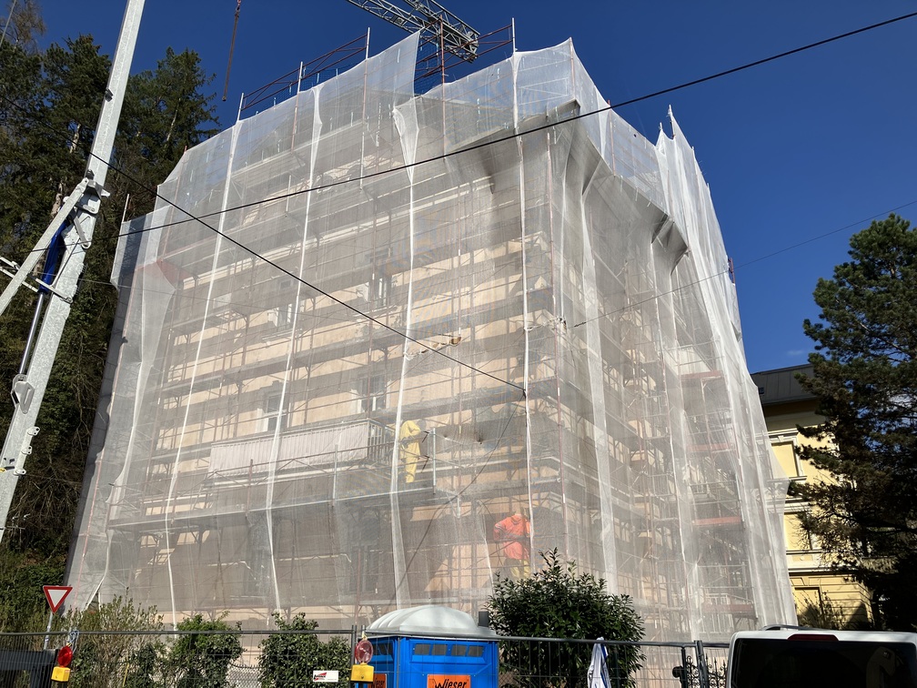 Mehrparteienhaus während einer Sanierung in Salzburg mit Baugerüst und professioneller Bauleitung durch SCURA Bau
